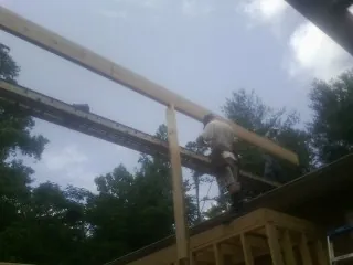 Carpenter setting a ridge beam over a new addition frame — Ice Dam Removal by Roofing Brothers in Fuquay Varina