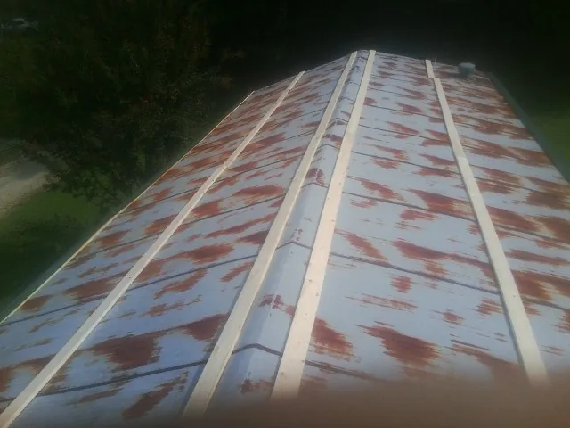 Rusted metal roof panels with new wood purlins before replacement — Storm Damage Roof Repair in Fuquay Varina by Roofing Brothers