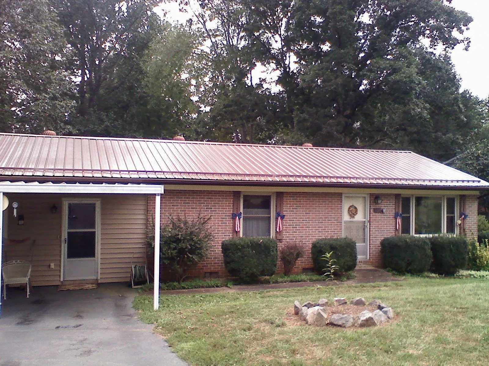 Bronze metal roof and carport on a brick ranch home — Roof Repair work by our crew in Fuquay Varina