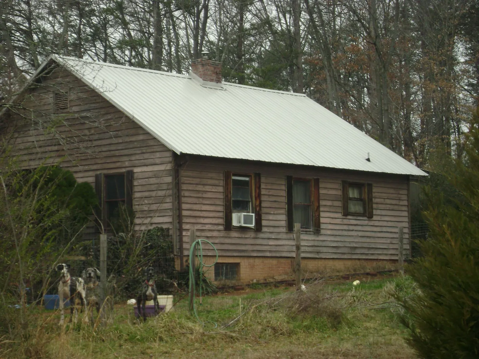 White metal roof on an old wood sided farmhouse, from a Metal Roof Installation job in Fuquay Varina